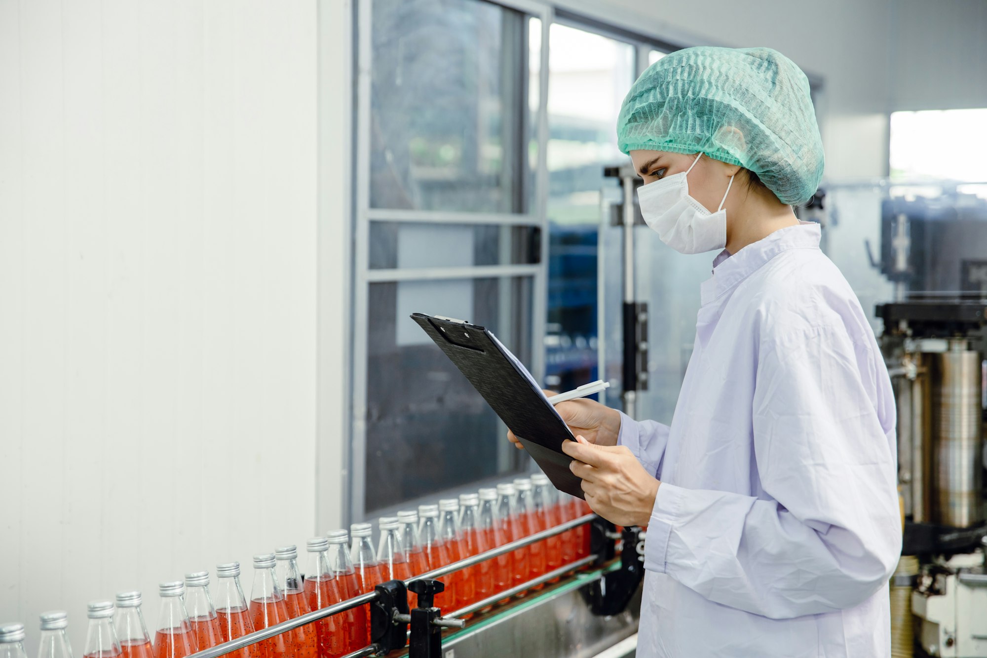 food and drink industry staff worker working at conveyor belt production line in beverage factory
