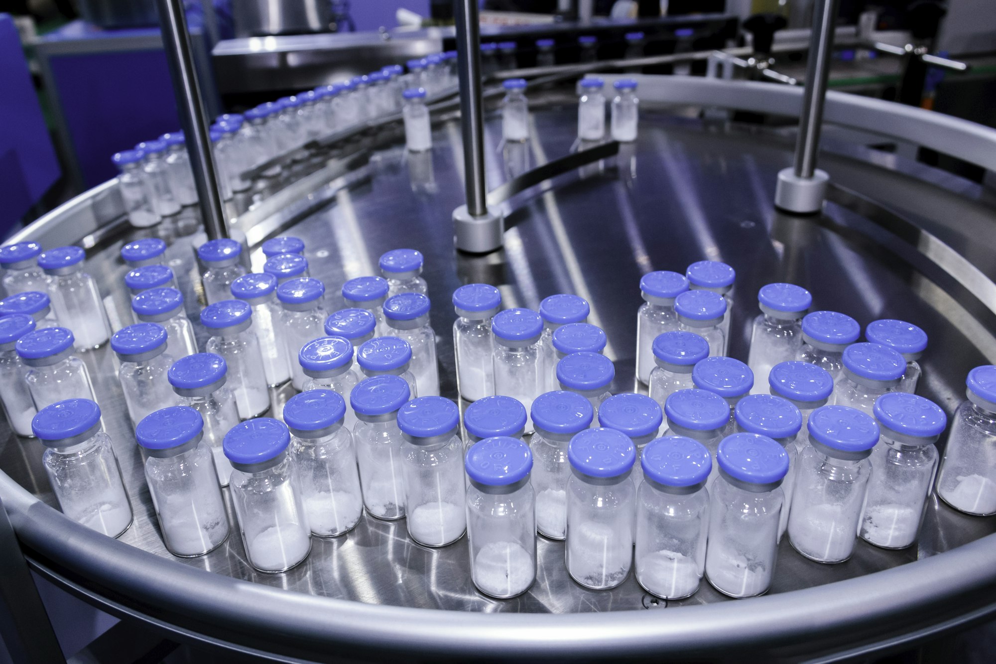 medicine glass bottle in pharmaceutical production line on conveyor belt in manufacturing.